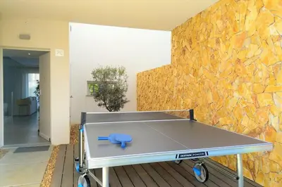 a ping pong table in front of a stone wall at Villa Ray Design in Albufeira