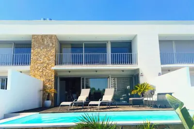 a house with a swimming pool in front of a building at Villa Ray Design in Albufeira