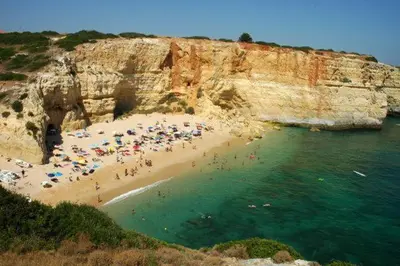 a group of people on a beach near the water at Casa da Praia dos Pescadores in Albufeira