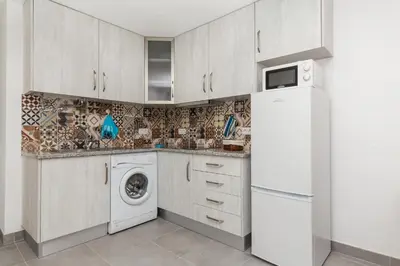 a kitchen with a white refrigerator and a washing machine at Casa da Praia dos Pescadores in Albufeira
