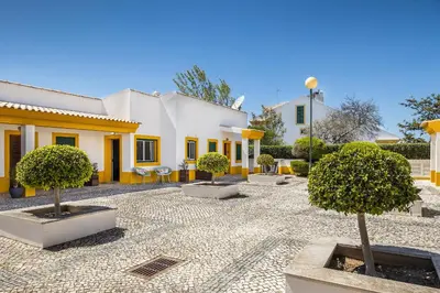 a courtyard with trees in front of a building at Nuances do Oceano by OCvillas in Albufeira