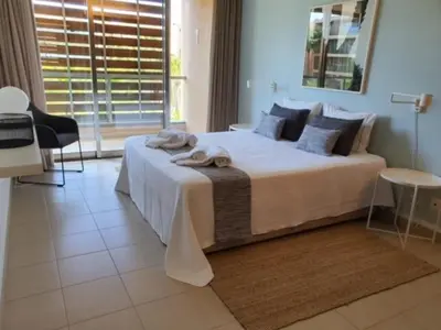 a bedroom with a large bed with towels on it at Ambassador Salgados Beach Suites in Albufeira