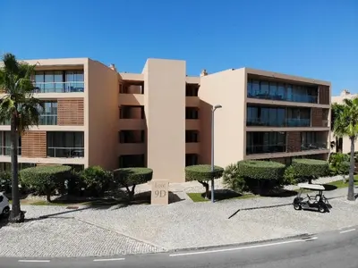 a large building with a parking lot in front of it at Ambassador Salgados Beach Suites in Albufeira