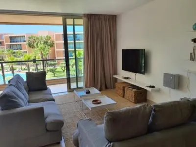 a living room with a couch and a flat screen tv at Ambassador Salgados Beach Suites in Albufeira