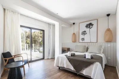 a white bedroom with a bed and a window at Vila Hibisco by Garvetur in Vilamoura