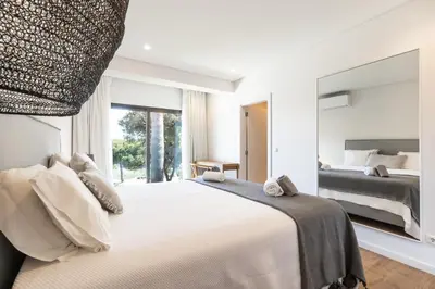 a bedroom with a large bed and a large mirror at Vila Hibisco by Garvetur in Vilamoura