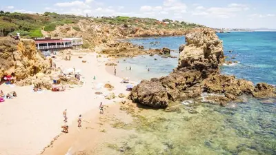 a group of people on a beach with rocks at 125 Oliveiras Terraces in Albufeira
