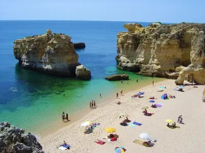 a group of people on a beach with umbrellas at 125 Oliveiras Terraces in Albufeira