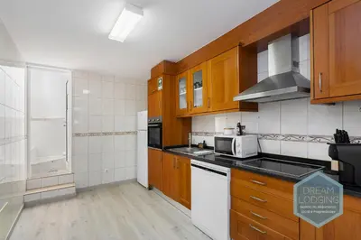 a kitchen with wooden cabinets and white appliances at Old Town - Albufeira - Dream Lodging in Albufeira