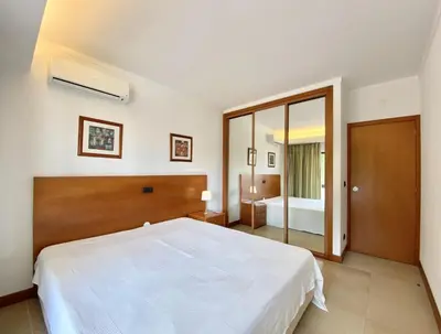a bedroom with a large white bed and a bathroom at Alvaflor - Vilamoura in Vilamoura