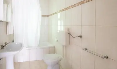 a white bathroom with a toilet and a sink at Apartamentos Pedro for Families by Bedzy in Albufeira
