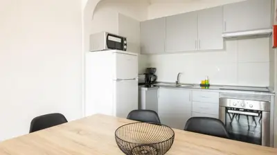 a kitchen with a table and chairs and a refrigerator at Apartamentos Pedro for Families by Bedzy in Albufeira