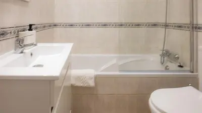 a bathroom with a sink and a tub and a toilet at Apartamentos Pedro for Families by Bedzy in Albufeira