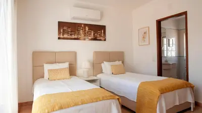 a bedroom with a large bed with blue pillows at Villa do Mar - Galé in Albufeira