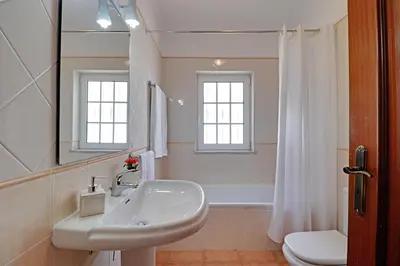 a white bathroom with a sink and a toilet at Villa do Mar - Galé in Albufeira
