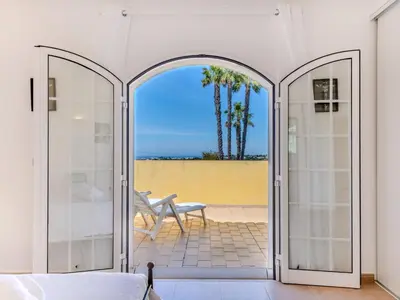 an open door to a patio with a chair at Villa Villa Monte da Torre by Interhome in Loulé