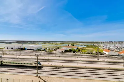 a train is on the tracks in a city at The Nest Apartment - Sea View - Faro in Faro