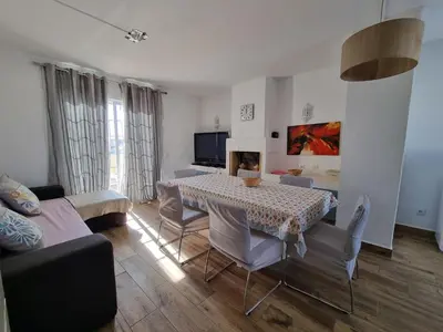 a living room with a dining room table and chairs at Sea view Penthouse 10 min walking Albufeira old town and Beach Pescadores in Albufeira