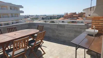 a wooden table and chairs on a roof at Sea view Penthouse 10 min walking Albufeira old town and Beach Pescadores in Albufeira