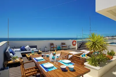 a patio with a table and chairs on a roof at Casa da Bandeira -Perfect Location-Beach front- Rooftop Pool by DreamvillasAlbufeira in Albufeira