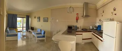 a kitchen with a white refrigerator and a table at FLOR DO VALE - APARTAMENTOS TURISTICOS in Guia