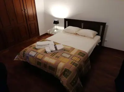 a bedroom with a bed with two towels on it at Minha casa in Faro