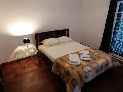 a bedroom with a bed and a table with a lamp at Minha casa in Faro