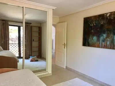 a bedroom with a mirror and a dog laying on the floor at Praia da Falésia - Falesia Beach - Apartment Pine Sun Park in Albufeira