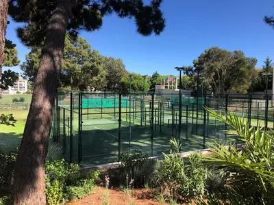 a tennis court in a park next to a tree at Praia da Falésia - Falesia Beach - Apartment Pine Sun Park in Albufeira