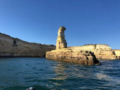 a stone pillar on a island in the water at Appartement Sao Rafael praia Algarve portugal in Albufeira