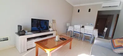 a living room with a couch and a tv and a table at Encosta S. José -Vale Parra in Albufeira