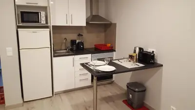 a small kitchen with a black counter and a refrigerator at Vila Magna Albufeira in Albufeira