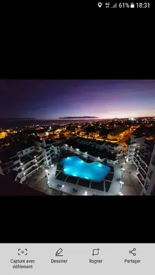 a picture of a building with a pool at night at Vila Magna Albufeira in Albufeira