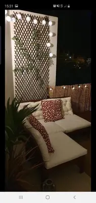 a couch with pillows on a balcony with a plant at Vila Magna Albufeira in Albufeira
