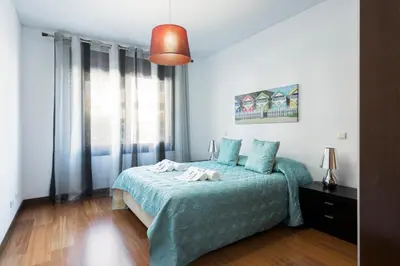 a bedroom with a bed with a blue bedspread at Apartamento Monte Laguna in Vilamoura
