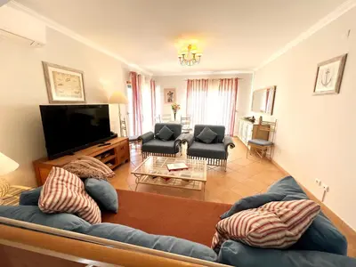 a living room with two couches and a flat screen tv at Vila Falesia Penthouse in Albufeira
