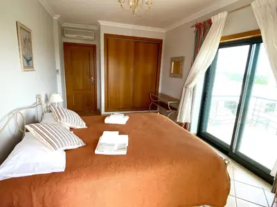 a large bed in a room with a large window at Vila Falesia Penthouse in Albufeira