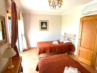 a bedroom with two beds and a lamp and a window at Vila Falesia Penthouse in Albufeira