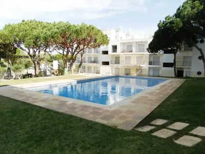 a swimming pool in front of a building at Vila Falesia Penthouse in Albufeira