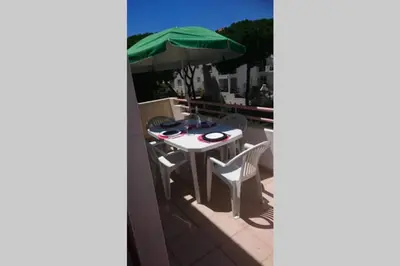 a table and chairs on a balcony with an umbrella at Falesia - near the beach - The GAVEL Apartment in Albufeira