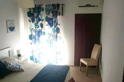 a bedroom with a bed and a chair and a window at Falesia - near the beach - The GAVEL Apartment in Albufeira