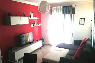 a red living room with a couch and a tv at Falesia - near the beach - The GAVEL Apartment in Albufeira