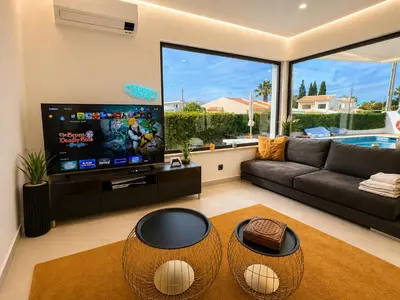 a dining room with a glass table and black chairs at Villa Cristina 17 - 500 m from the Beach in Albufeira