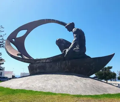 a statue of a man sitting on a boat at 