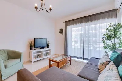 a living room with a couch and a tv at Colina Sol T2 Quarteira Beach in Quarteira