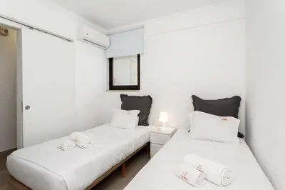 two beds in a room with white walls at Elma By Albufeira Rental in Albufeira