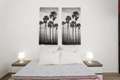 a bedroom with a bed with palm trees on the wall at Elma By Albufeira Rental in Albufeira