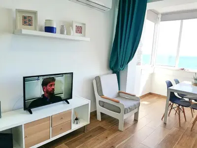 a living room with a flat screen tv on a cabinet at Mira Praia, Sunny and Sea in Quarteira