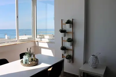 a dining room with a table and a view of the ocean at Mira Praia, Sunny and Sea in Quarteira