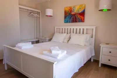 a bedroom with a white bed with a painting on the wall at Holiday house in elite residential area of Faro in Faro